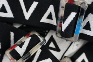 A close up image of a black and white Davy J logo belt with recycled belt buckle. 