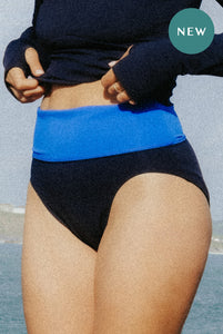 A close up of a woman wearing a pair of Davy J sustainable waterwear high leg bikini briefs with a deep blue waist band
